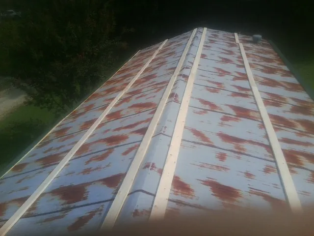 Rusted metal roof panels with new wood purlins before replacement — Storm Damage Roof Repair in North Branch by Roofing Brothers